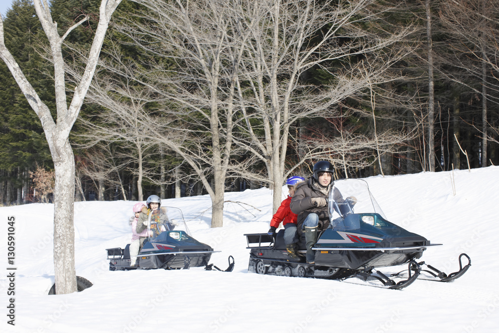Family riding on snowmobiles 