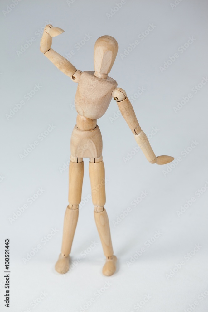 Wooden figurine standing with hand raised Wooden figurine standing with hand raised