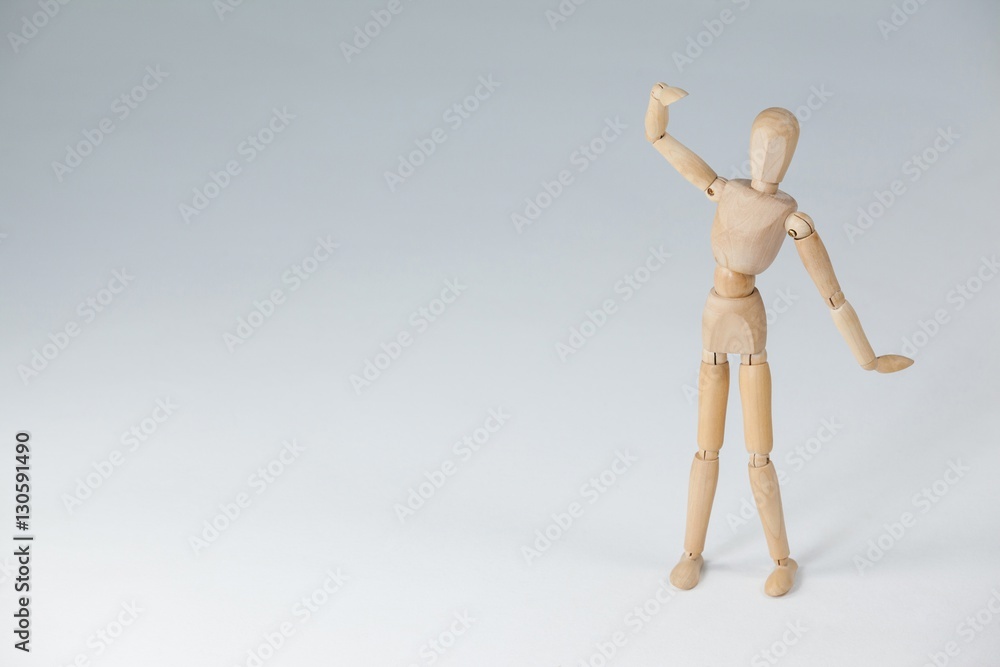 Wooden figurine standing with hand raised Wooden figurine standing with hand raised
