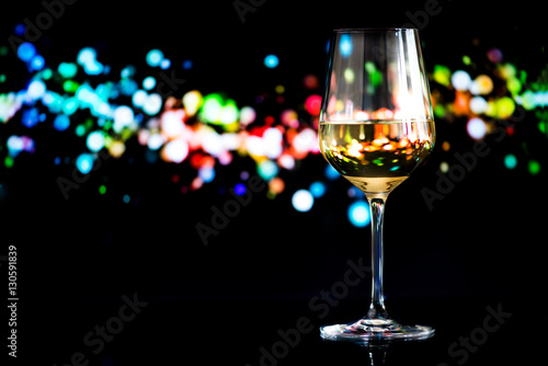 glass of white wine against a glowing bokeh - copy space, select