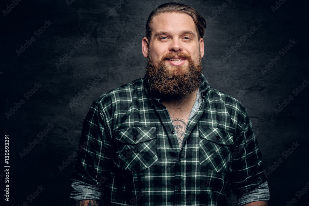 Obraz premium Smiling bearded male in a green plaid shirt.