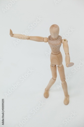 Wooden figurine standing and showing hand stop sign