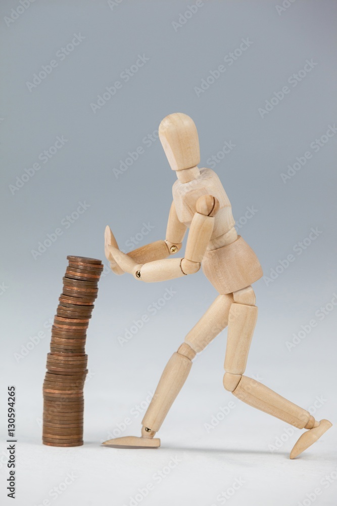 Wooden figurine preventing stack of coins from falling Wooden figurine preventing stack of coins from falling