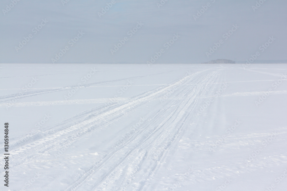 The road on snow cover of the frozen river in the winter