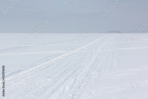 The road on snow cover of the frozen river in the winter
