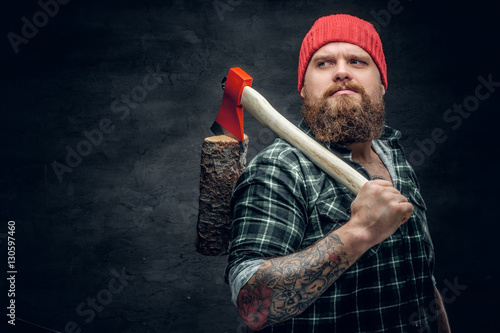 Canvas-taulu Lumberjack dressed in a green shirt holds the red axe.
