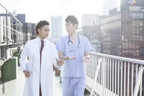 Two doctors are talking on the roof of the hospital
