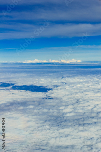飛行機の窓から見える 雲 青空 陸 
