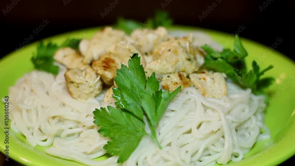 Pasta. Spaghetti with chicken pieces and parsley on a green plate. Circular motion. Pasta. Spaghetti with chicken pieces and parsley on a green plate. Circular motion.
