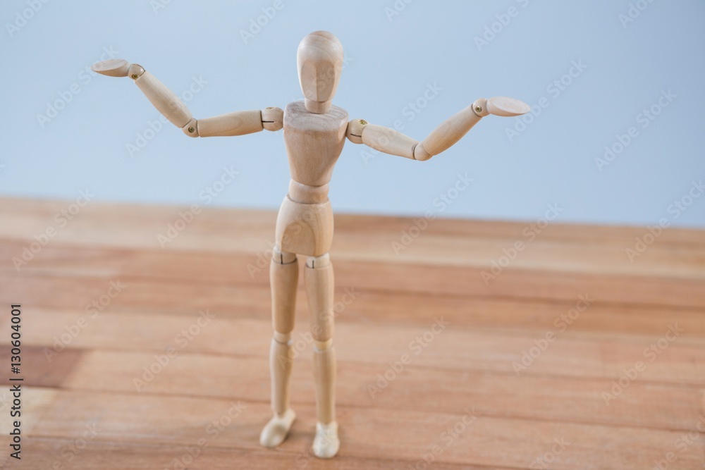 Fototapeta premium Wooden figurine standing with arms spread