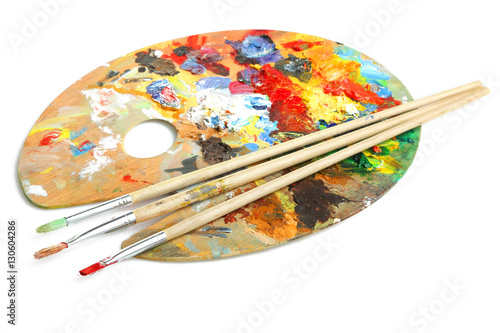 Wooden art palette and a brush on white background.