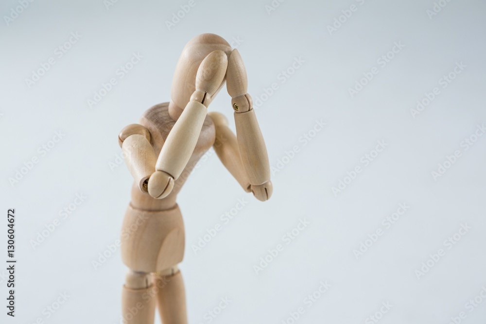 Tired wooden figurine with hand on forehead Tired wooden figurine with hand on forehead
