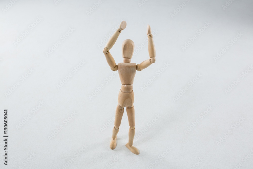 Wooden figurine standing with hand raised Wooden figurine standing with hand raised