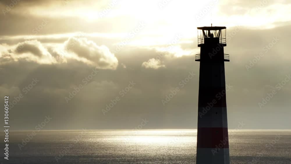 Timelapse lighthouse on the sea under stormy clouds and with the ship in the background Timelapse lighthouse on the sea under stormy clouds and with the ship in the background