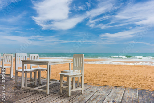 wood floor and seaside table with beach and sea background © lersan