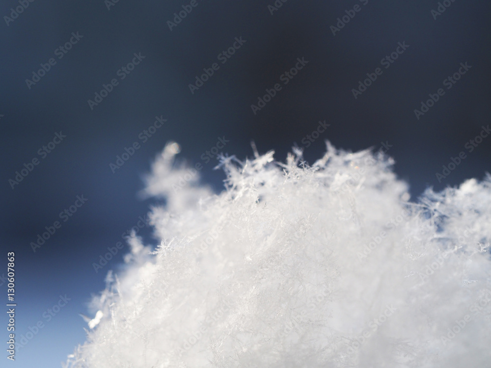 White snowflakes on a dark background macro. Abstract winter background. White snowflakes on a dark background macro. Abstract winter background.