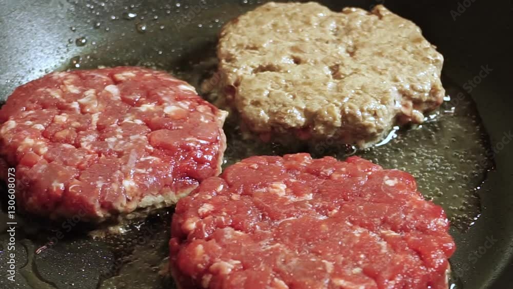 Cooking hamburger. Three beef cutlets for burgers are fried in a frying pan. HD Cooking hamburger. Three beef cutlets for burgers are fried in a frying pan. HD