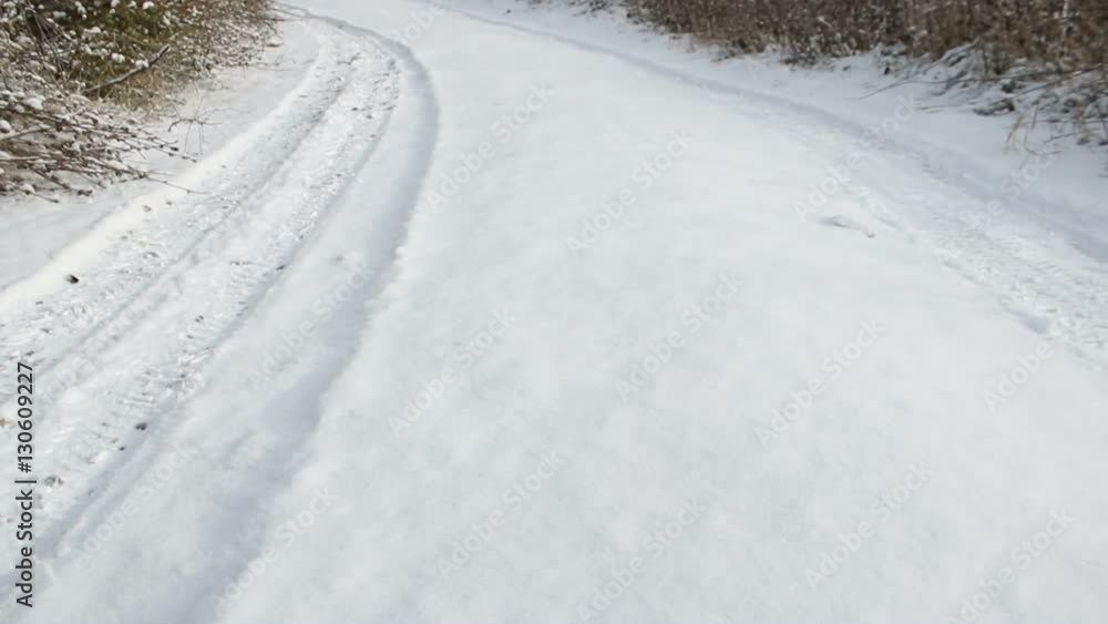 Snow path with car tracks on a sunny day. Camera moving through snow road Snow path with car tracks on a sunny day. Camera moving through snow road