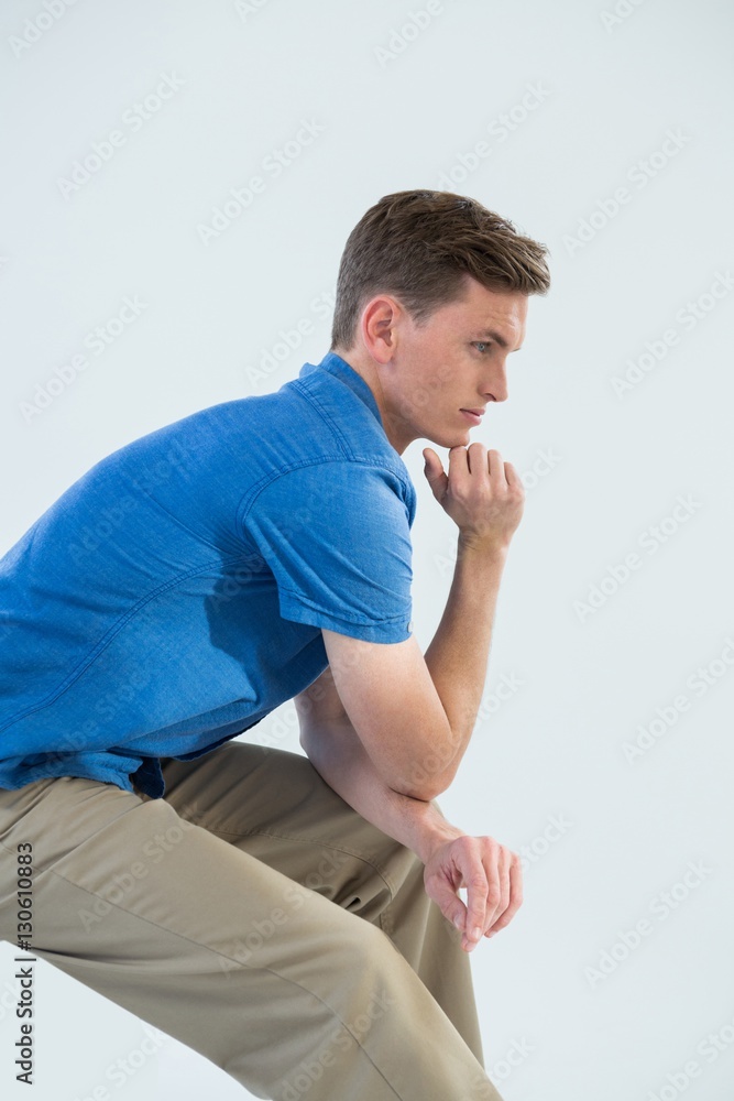 Man in blue shirt with hand on chin Man in blue shirt with hand on chin