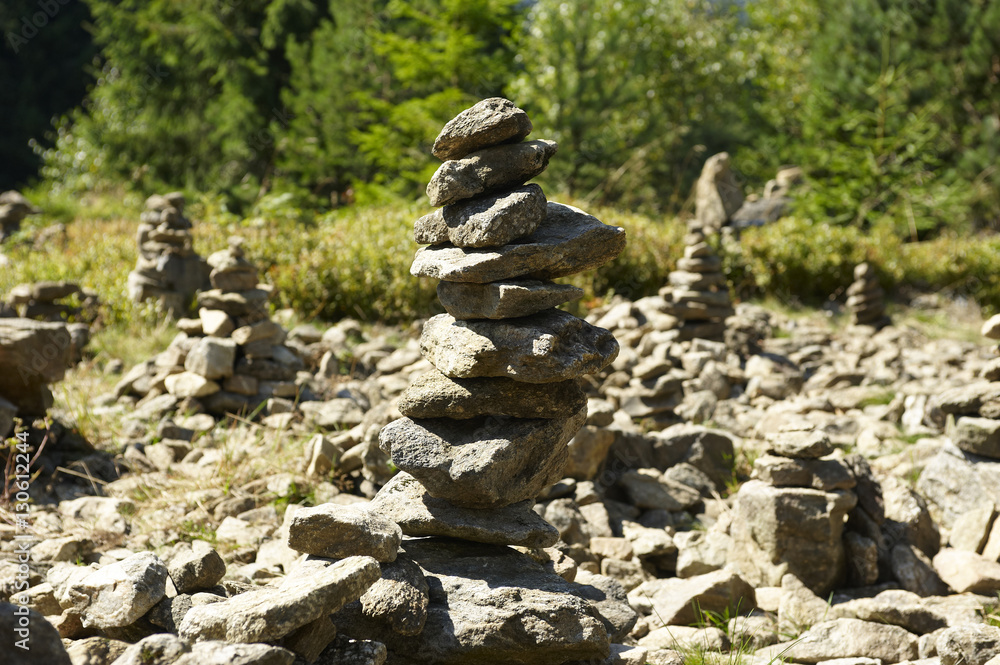 Harmony and balance, poise stones against the forest in the mountains, rock zen sculpture, sunny day Harmony and balance, poise stones against the forest in the mountains, rock zen sculpture, sunny day