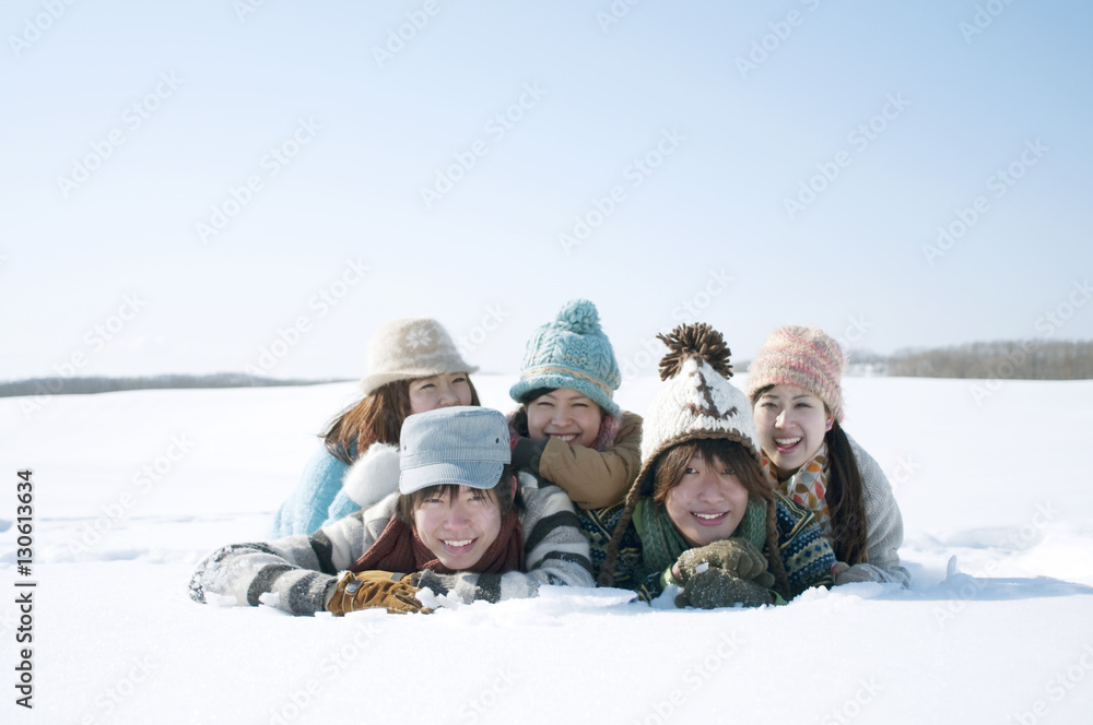雪原に寝転び微笑む若者たち