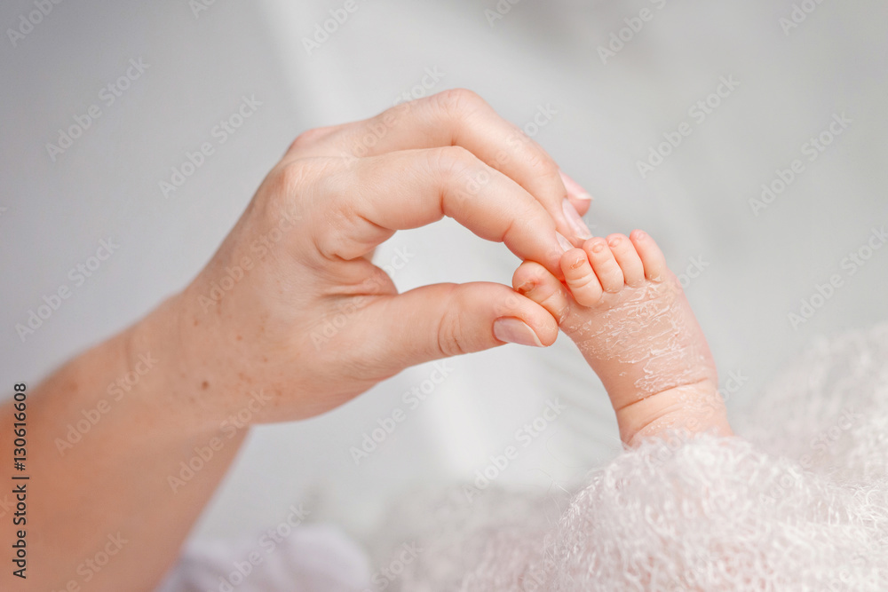 Baby foot in mother hands. Tiny Newborn Baby's feet on female S Baby foot in mother hands. Tiny Newborn Baby's feet on female S