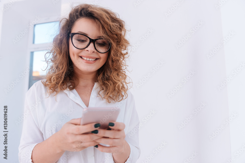 Smiling Woman in shirt writing message on phone Smiling Woman in shirt writing message on phone