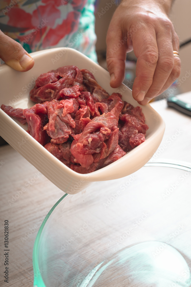 Putting raw meat in the baking dish vertical Putting raw meat in the baking dish vertical