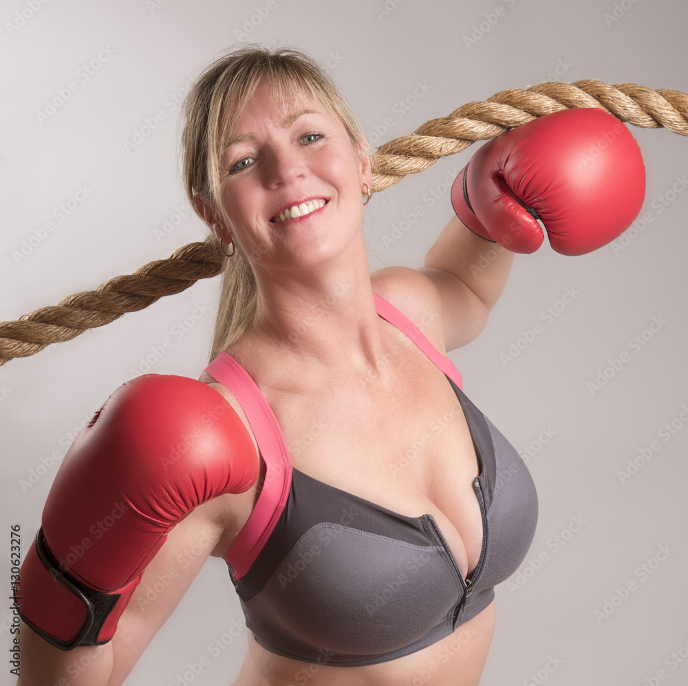 Attractive woman boxer wearing a black sports bra and red gloves