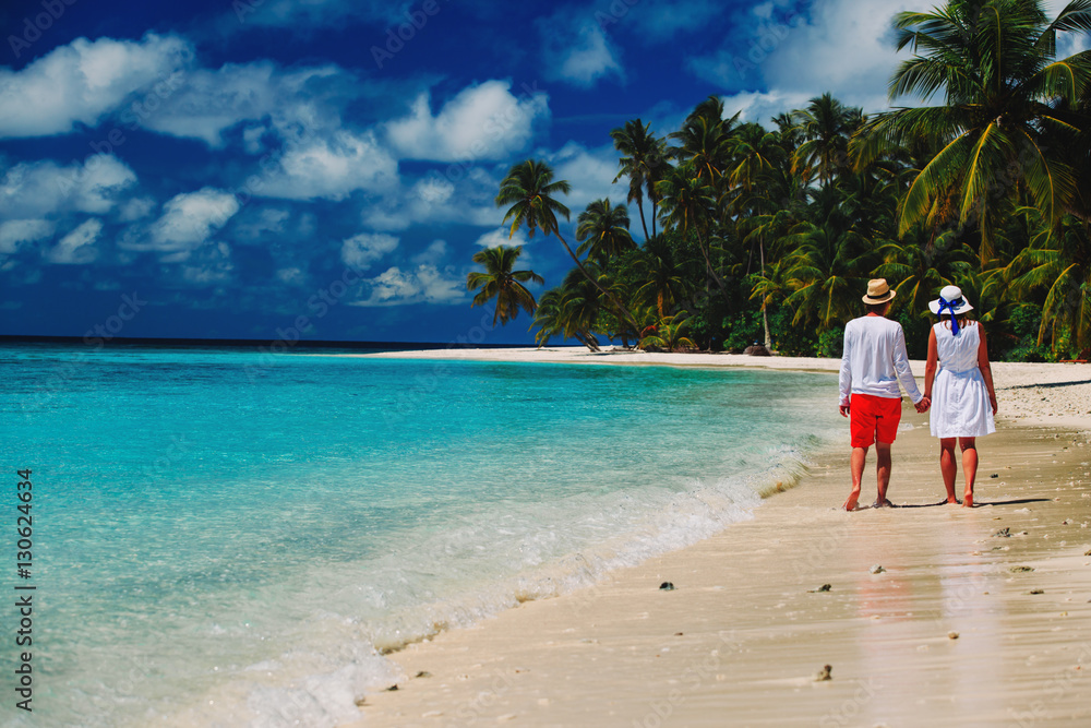 happy loving couple walking on beach