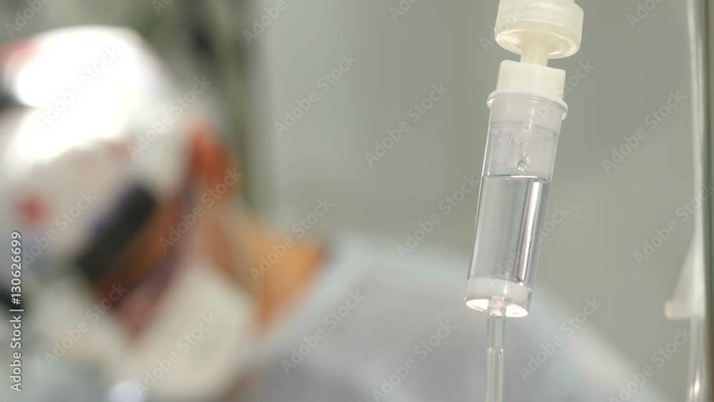 Intravenuos dropper in surgery room. Surgeons during surgical operation Intravenuos dropper in surgery room. Surgeons during surgical operation