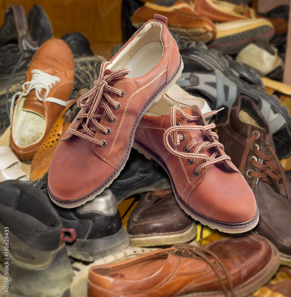 New mens shoes on pile of old different worn footwear Stock Photo | Adobe  Stock