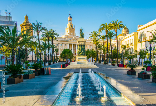 View of a fountain situated on the square of saint john of god in cadiz with town hall on background photo