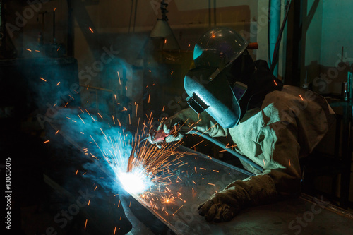 Welder of Metal Welding with sparks and smoke in manufacturing
