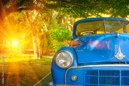 Detail of front view blue retro car with lighting flare effect. Vintage style © iphotothailand