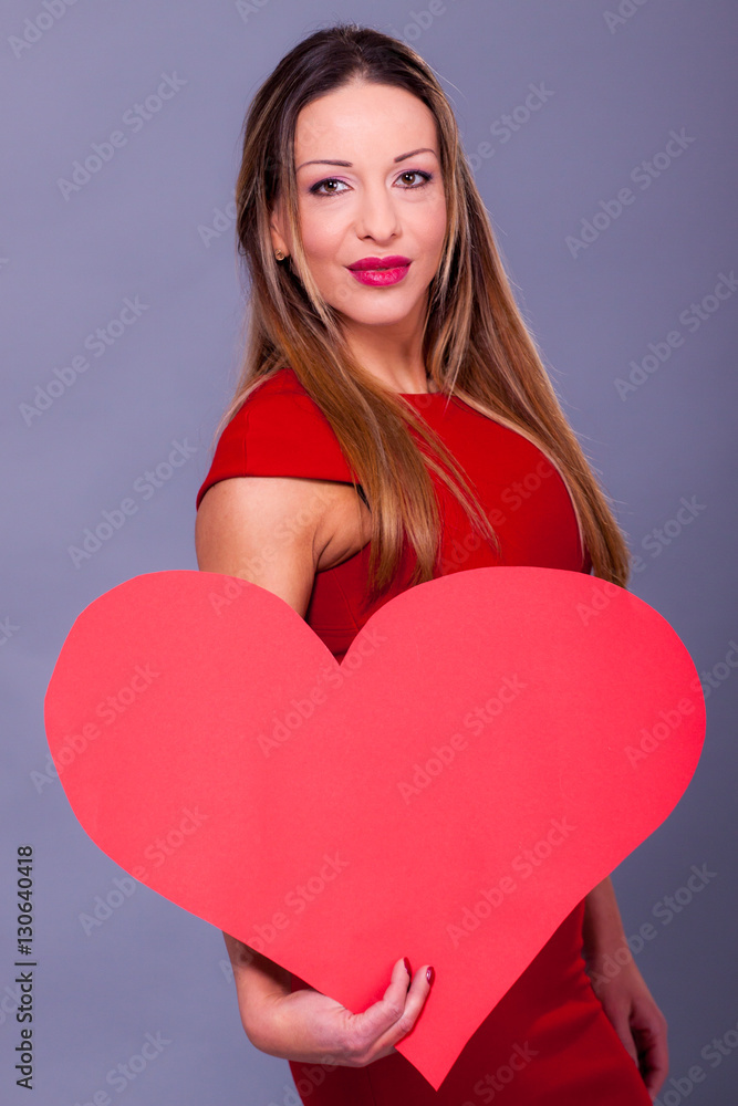 Woman wearing red dress holding big heart sign love symbol Woman wearing red dress holding big heart sign love symbol