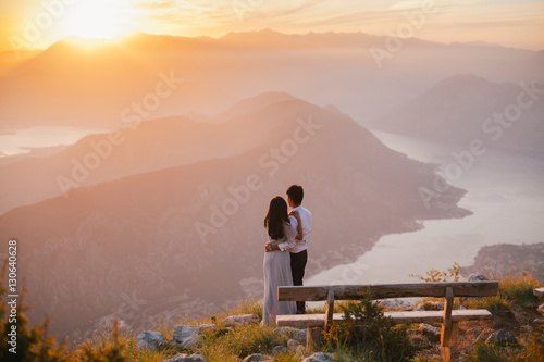 honeymoon couple kiss and embrace at sunset