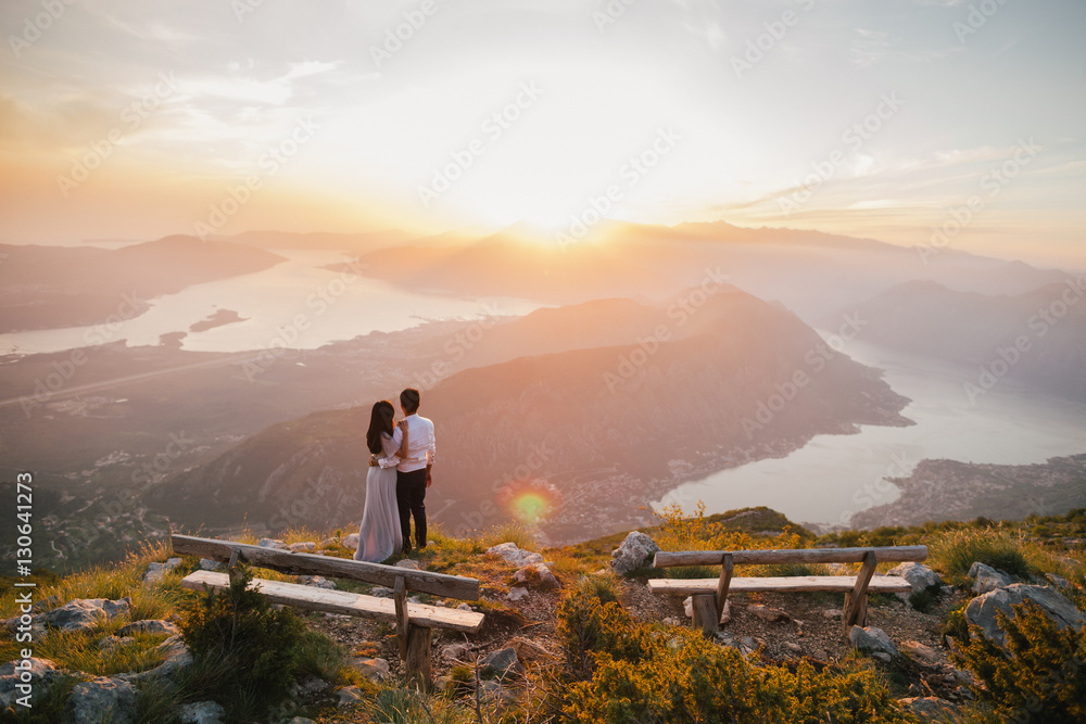 Fototapeta premium honeymoon couple kiss and embrace at sunset