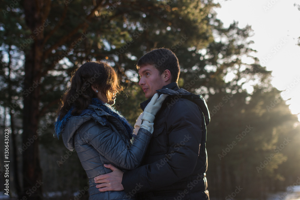 Happy couple in winter park with beautiful sun rays. Happy couple in winter park with beautiful sun rays.