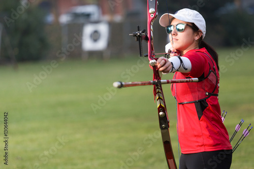 Female athlete practicing archery in stadium