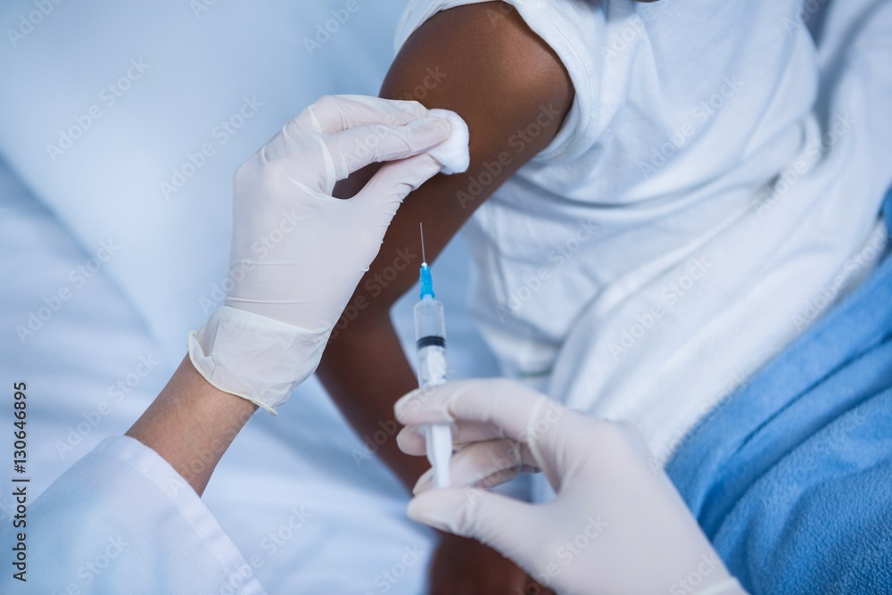 Doctor giving an injection to patient in ward Doctor giving an injection to patient in ward