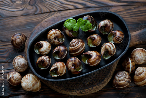 Escargot snails with garlic butter in a rustic wooden setting