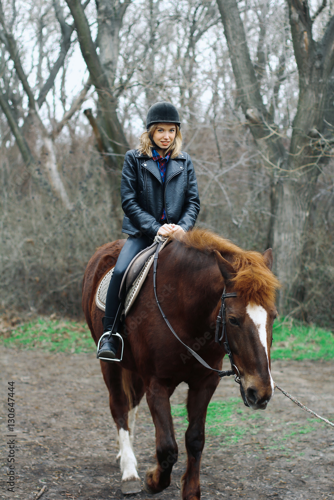 girl smiling while sitting on a horse in the forest