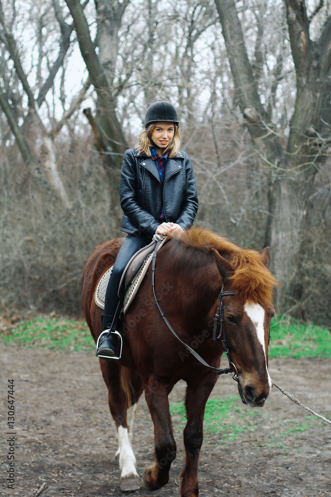 girl smiling while sitting on a horse in the forest girl smiling while sitting on a horse in the forest