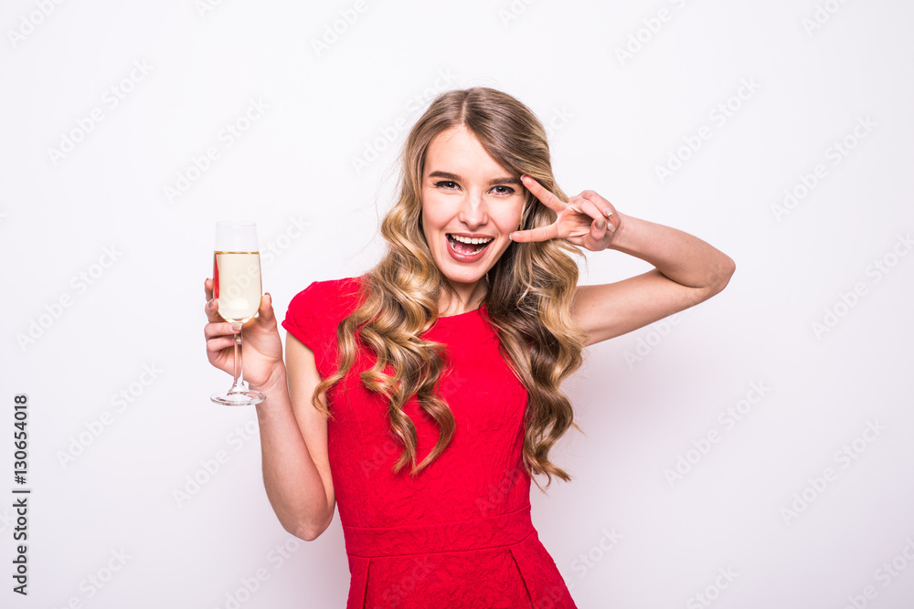 Pretty young woman in red dress drinking champagne over white background Pretty young woman in red dress drinking champagne over white background