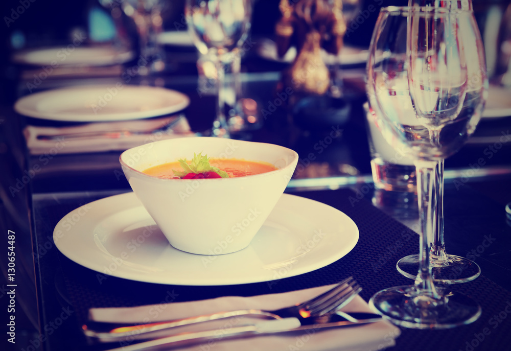 Pumpkin soup on restaurant table, toned