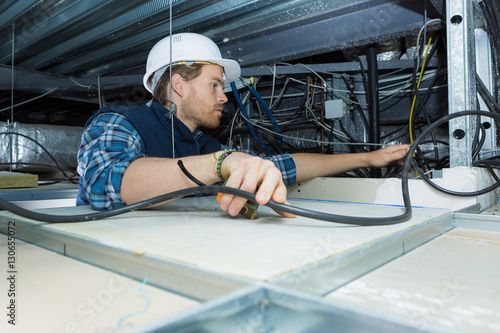 electrician fitting a cable for ceiling light