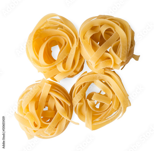 Italian fettuccine or tagliatelle pasta nests isolated on white background.