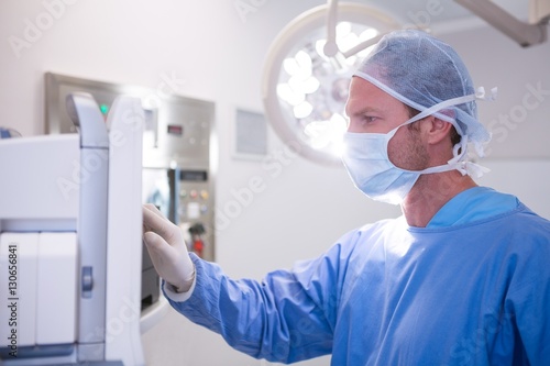 Male surgeon using machine in operation theater