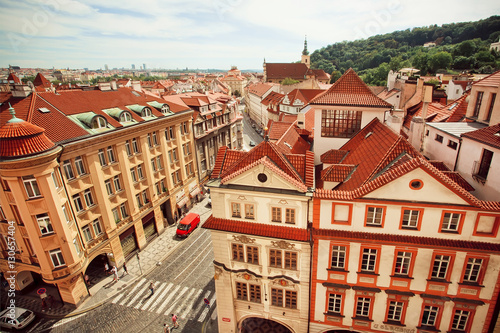 City landscape with red tiles on roofs and historical street of old Prague